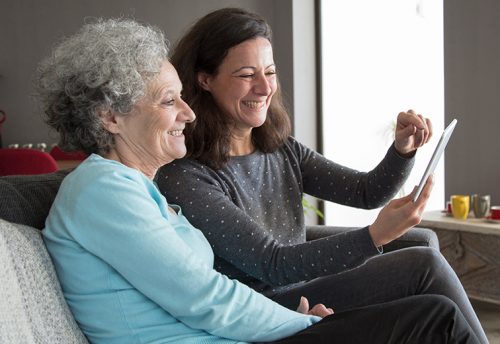 Happy Elderly Woman and Her Daughter Browsing Tablet Computer | Stroke Recovery Foundation